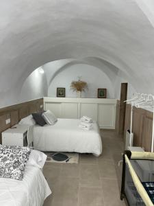 1 dormitorio con 2 camas y techo abovedado en Casa Abuelo Miguel, en Arcos de la Frontera