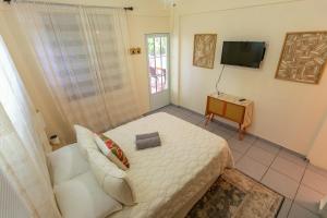 Dormitorio pequeño con cama y TV en Casa Pina Suave #1, en Rincón