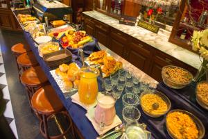 uma linha de buffet com comida e bebidas numa mesa em Tanguero Hotel Boutique Antique em Buenos Aires