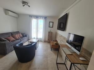 a living room with a couch and a tv at Appartement Vacances ZEN in Fréjus