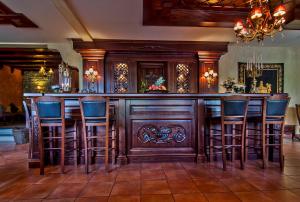 a bar in a room with wooden bar stools at Hotel Doupiani House in Kalabaka