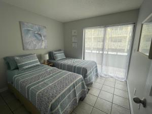 a bedroom with two beds and a window at Glory Beach Haven in Venice