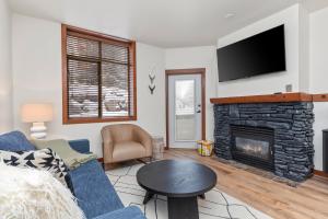 a living room with a blue couch and a fireplace at Powderhorn Lodge 102: Sego Lily Suite in Solitude