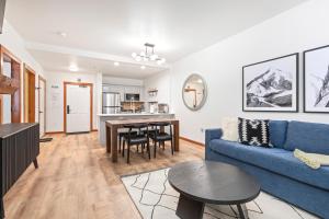 a living room with a blue couch and a table at Powderhorn Lodge 102: Sego Lily Suite in Solitude