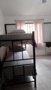 2 Etagenbetten in einem Zimmer mit Fenster in der Unterkunft Posada de la Costa in Villa Carlos Paz