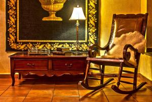 a room with a chair and a desk with a lamp at Hotel Doupiani House in Kalabaka