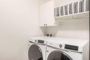 uma lavandaria branca com máquina de lavar e secar roupa em 86 Moose Ridge em Big Sky
