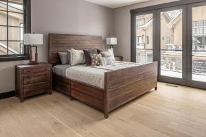 Un dormitorio con una gran cama de madera con almohadas en 86 Moose Ridge en Big Sky