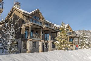 a large wooden house in the snow in front at 86 Moose Ridge in Big Sky