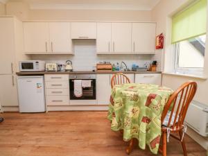 a kitchen with a table with a tablecloth on it at Peek A Boo in Beaworthy