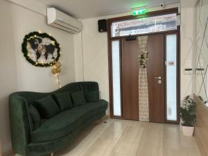 salon z zieloną kanapą i drzwiami w obiekcie City Plaza Apartments & Rooms w Salonikach