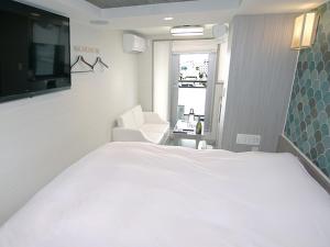 a bedroom with a large white bed and a chair at Hotel Opera in Tokyo