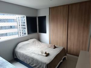 1 dormitorio con 1 cama con 2 toallas en 100 Metros do Mar - Ponta Verde, en Maceió