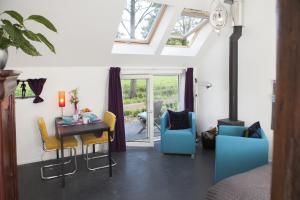 sala de estar con mesa y sillas en Logement de Kaap en Terheijl
