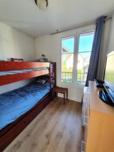 a bedroom with a bunk bed and a desk with a computer at Résidence Port Guillaume - maeva Home - Maison 3 pièces 6 personnes - Sélection MAE-4014 in Dives-sur-Mer