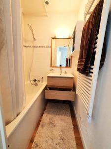a bathroom with a sink and a tub and a mirror at Résidence Port Guillaume - maeva Home - Maison 3 pièces 6 personnes - Sélection MAE-4014 in Dives-sur-Mer