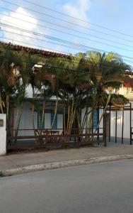 a group of palm trees in front of a building at Pousada Esmeralda in Maragogi