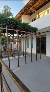 a pergola with plants on it in front of a building at Pousada Esmeralda in Maragogi