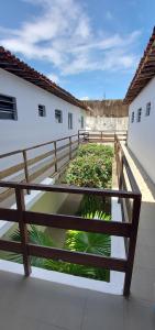 a wooden fence next to a courtyard with plants at Pousada Esmeralda in Maragogi