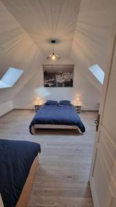 a bedroom with a bed with blue sheets in a attic at La Grange in Gasny