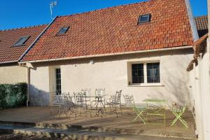 a patio with chairs and tables and a building at La Grange in Gasny