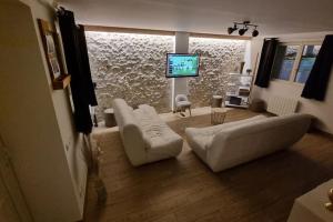 a living room with a couch and a tv at La Grange in Gasny