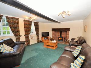 a living room with leather furniture and a fireplace at 3 Bed in Sidmouth HARRI in Talaton