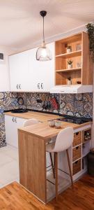 a kitchen with a wooden table and white cabinets at Azulejo Apartment in Novi Beograd