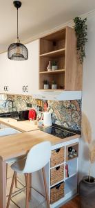 a kitchen with a wooden table and a white chair at Azulejo Apartment in Novi Beograd