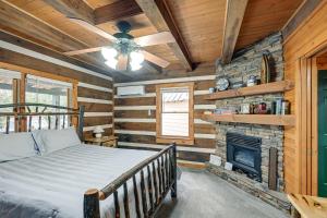 a bedroom with a bed and a fireplace at Rustic North Carolina Cabin with Fire Pit and Porch in Sylva