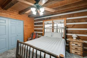 a bedroom with a bed and a ceiling fan at Rustic North Carolina Cabin with Fire Pit and Porch in Sylva