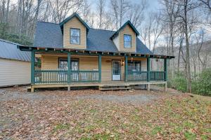 a house with a large porch on a yard at Rustic North Carolina Cabin with Fire Pit and Porch in Sylva