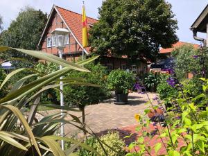 a garden in front of a house with plants at Mühlengasthof Landesbergen in Landesbergen