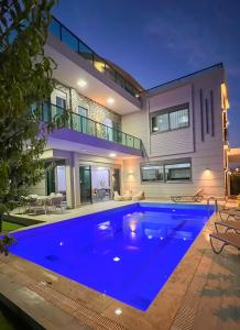 a large blue swimming pool in front of a house at Living Dream Villa HARMONY in Belek