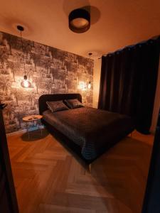 una camera con un letto in una stanza con un muro di TOTie a Grudziądz