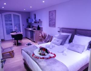 - une chambre dotée d'un grand lit avec une composition florale dans l'établissement Aux Charmes de la Vallée, à Béthisy-Saint-Pierre