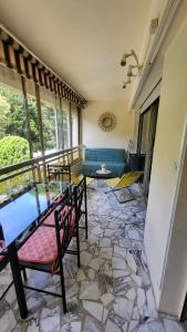 een woonkamer met een bank en een tegelvloer bij Appartement calme, cosy Piscine in Mandelieu-la-Napoule