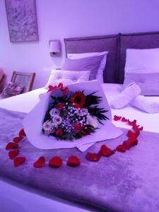 - un bouquet de fleurs sur un lit avec le cœur dans l'établissement Aux Charmes de la Vallée, à Béthisy-Saint-Pierre