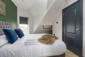 ein Schlafzimmer mit einem weißen Bett mit blauen Kissen in der Unterkunft GiGi's in Blackpool