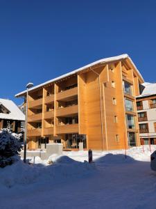 a large building with snow in front of it at Mondholz Ferienwohnung in Andermatt