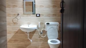 a bathroom with a toilet and a sink at Bequest Stays Celebration in Puri