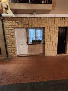 a brick wall with a white door and a window at Boomerang in Benidorm