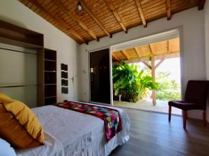 a bedroom with a bed and a large window at Villa BABYLAS in Sainte-Anne