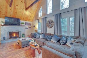 Pocono LakeにあるFamily-Friendly Cabin with Fire Pit in Pocono Lake!のソファと暖炉のあるリビングルーム
