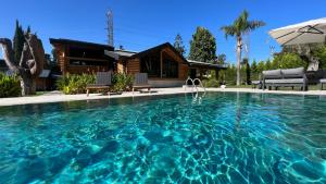 a swimming pool in front of a house at Living Dream Villa LIGNUM in Duacı