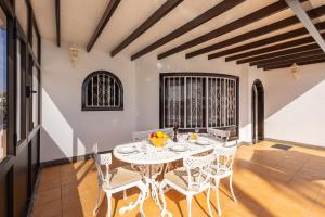 a dining room with a white table and chairs at Villa Alisa in Tías