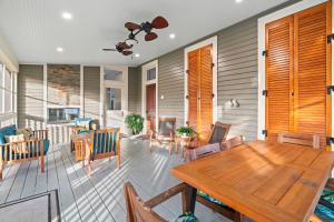 eine Veranda mit einem Holztisch und Stühlen in der Unterkunft Historic Galveston Family Beach Home With 3 King Beds in Galveston