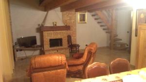 a living room with leather chairs and a fireplace at Agriturismo ErcolAna in Neviglie
