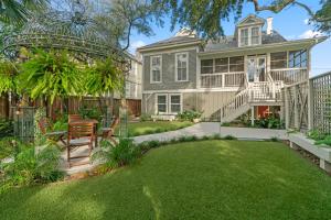 a large house with a yard with a table and chairs at Historic Galveston Family Beach Home With 3 King Beds in Galveston