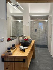 a bathroom with a counter with a sink and a shower at Nido di Laura in Santa Maria Maggiore